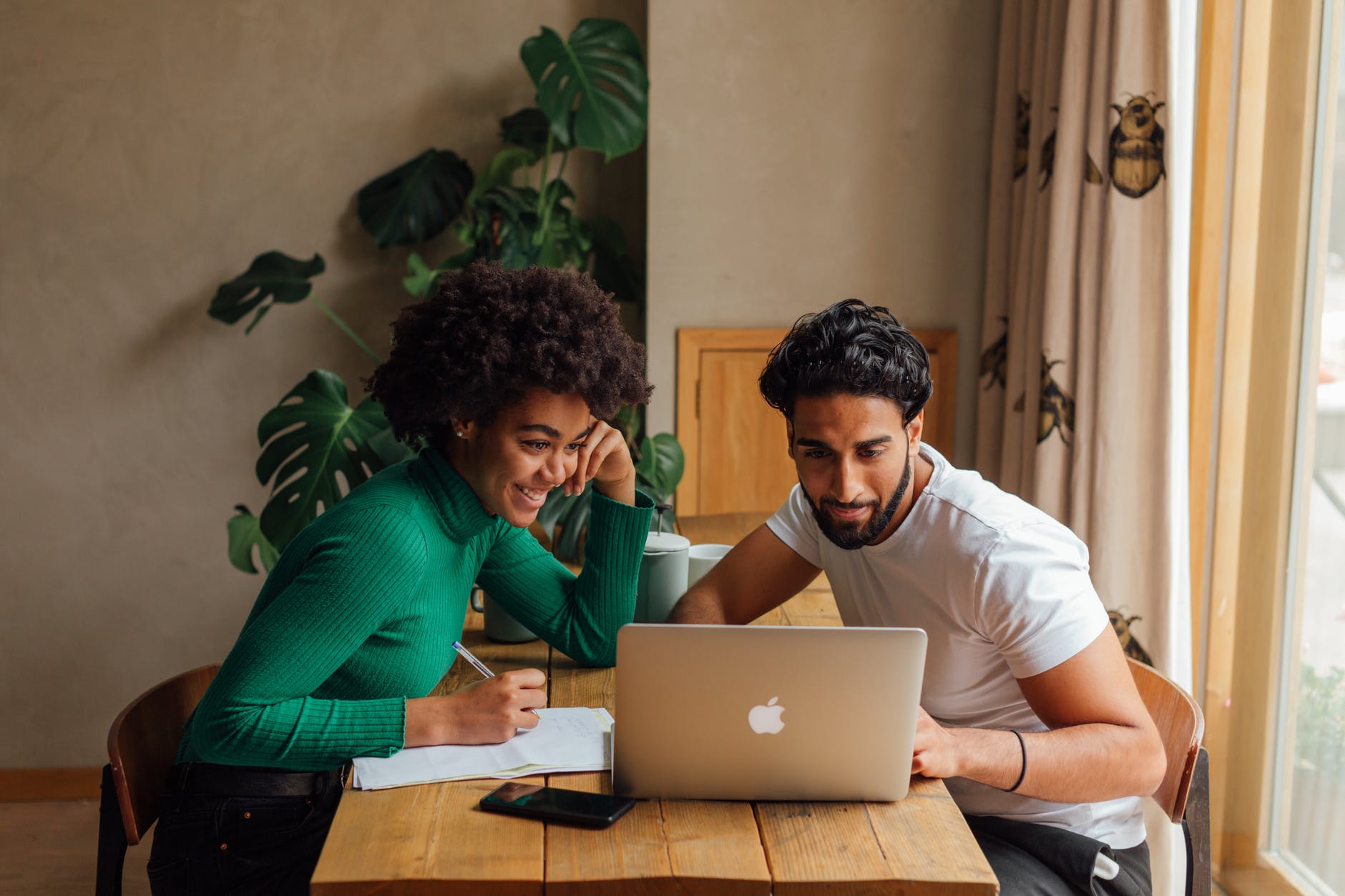 man in green sweater sitting beside woman in white crew neck shirt